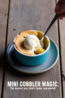 A single-serving mini cobbler in a ramekin with a scoop of vanilla ice cream on top