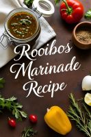 A jar of Rooibos marinade surrounded by fresh ingredients on a rustic wooden table.