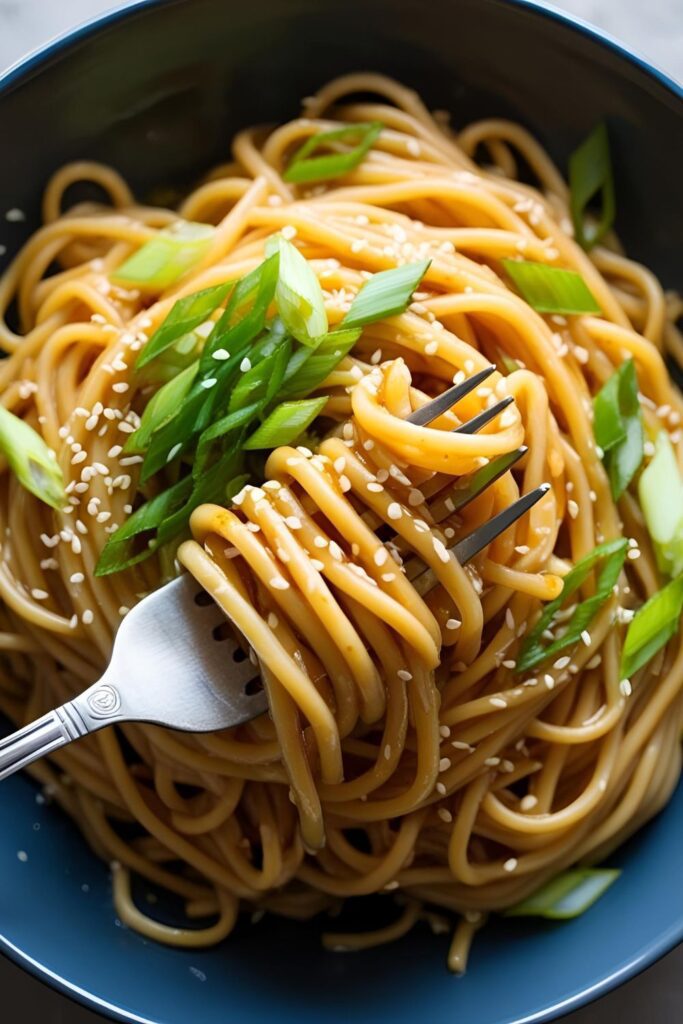 Overhead shot of a plate of 15-minute noodles with vibrant vegetables and chopsticks.