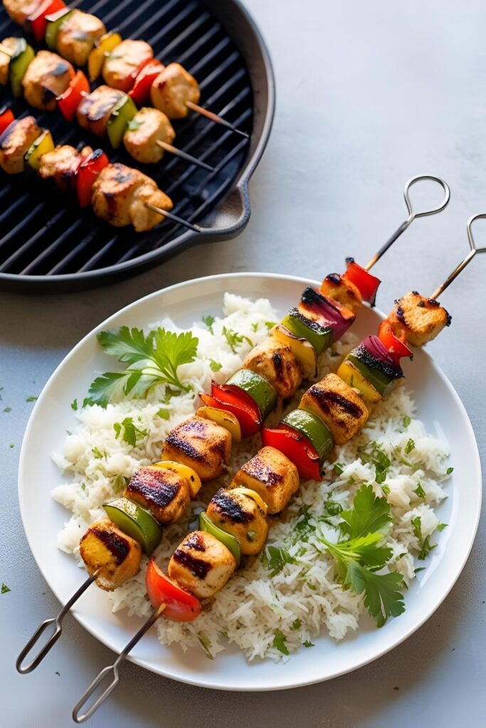 Juicy grilled skewers with chicken, bell peppers, and onions arranged on a wooden board with fresh herbs and dipping sauce.