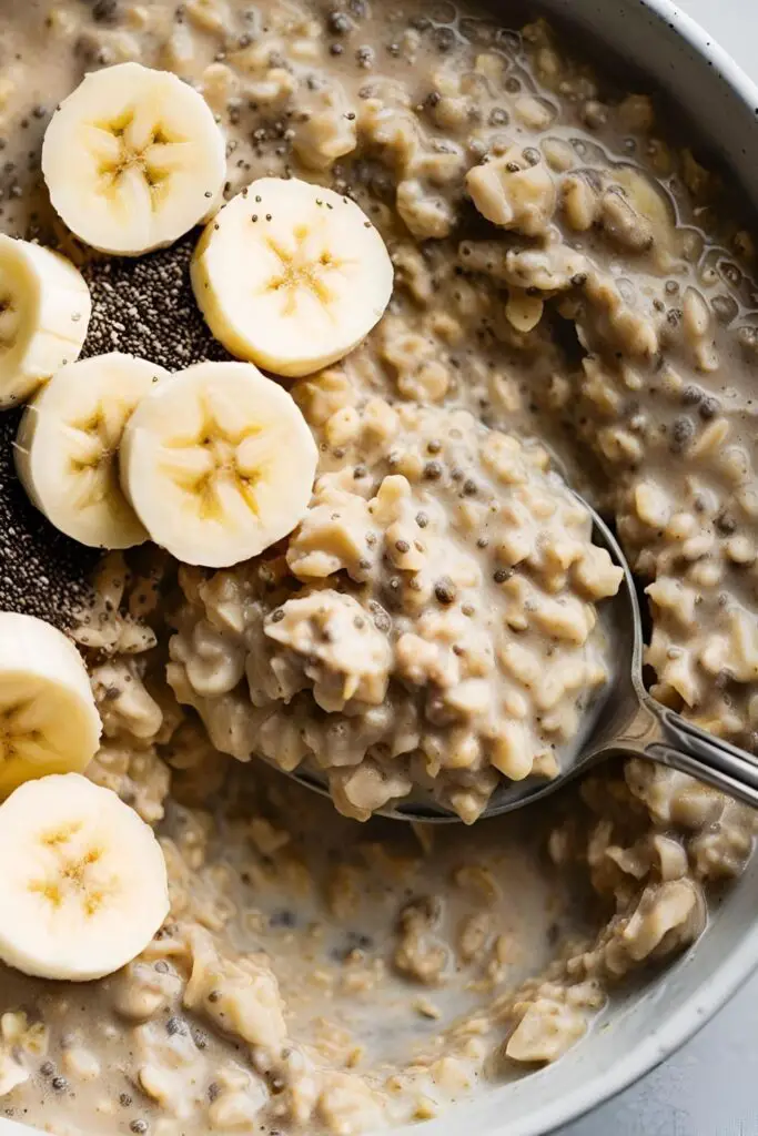 Side view of a bowl of coffee oatmeal with steam rising and a cup of coffee beside it.