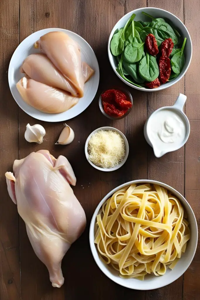 Close-up of creamy Tuscan chicken pasta with sun-dried tomatoes and spinach in a skillet.