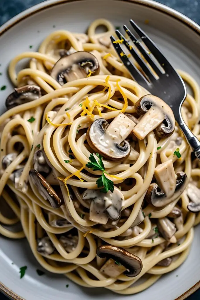 Overhead shot of vegetarian oyster mushroom pasta garnished with parsley and lemon zest.