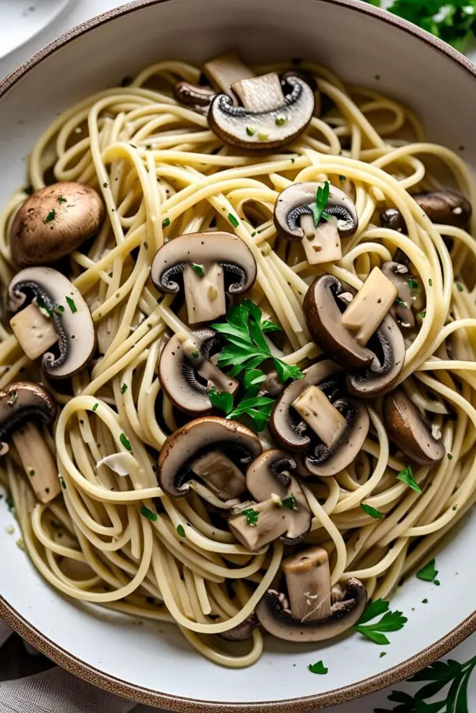 A mouthwatering plate of garlic butter mushroom pasta with parsley and parmesan toppings.