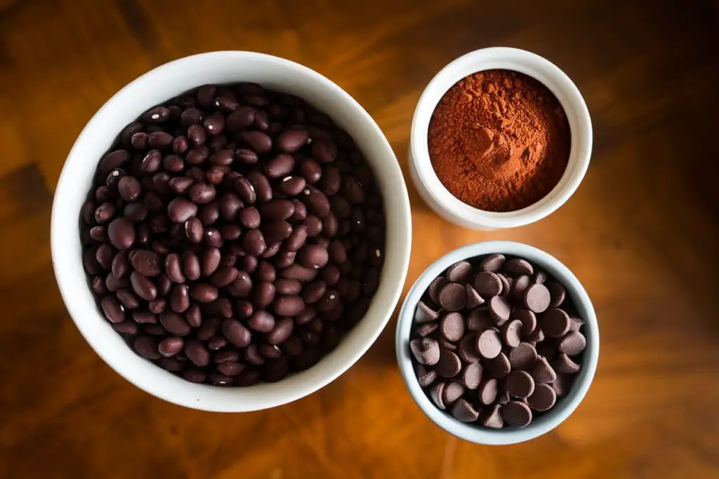 Cooked black beans, cocoa powder, and chocolate chips, key ingredients for healthy brownies.