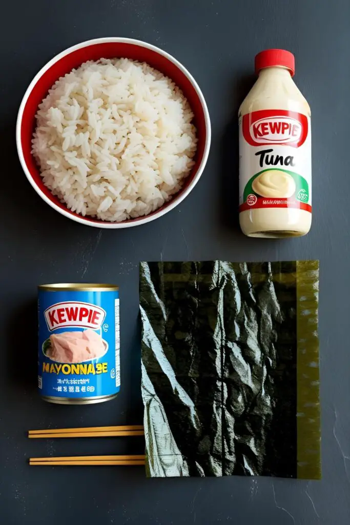 A flat lay of the key ingredients for making tuna mayo onigiri: short-grain rice, canned tuna, Japanese mayo, and nori.