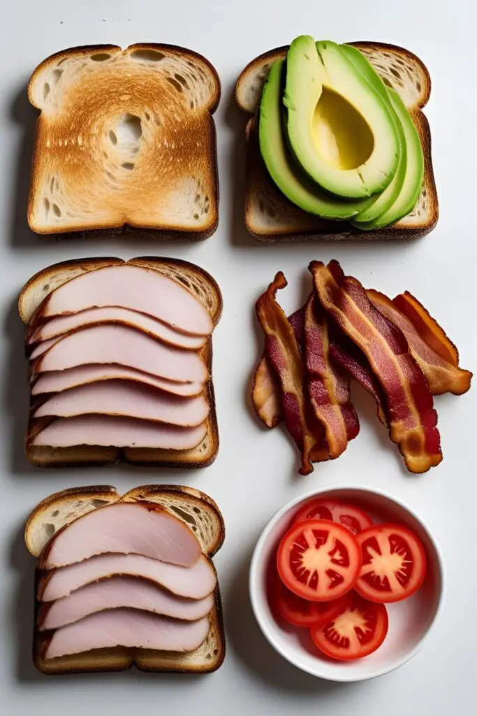  The fresh ingredients for the ultimate turkey pesto club sandwich, including turkey, bacon, avocado, and pesto aioli.